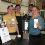 people holding starbucks cups